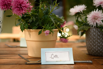 Table name card for Gaith and cutlery on a wooden table
