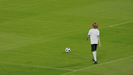 WIDE Caucasian pre teen kid boy entering the field of huge soccer stadium, holding a ball, dreaming of becoming professional player, soccer star