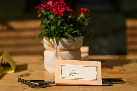 Table name card for Zain and cutlery on a wooden table