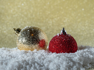 Christmas balls in the snow on a background of golden glitter.