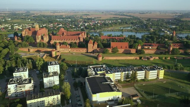 Malbork,Poland.Aerial 4K video from drone to Medieval Malbork ( Zamek w Maborku, Ordensburg Marienburg ),castle in Poland fortress of the Teutonic Knights at the Nogat river in sunrise light.(Series)