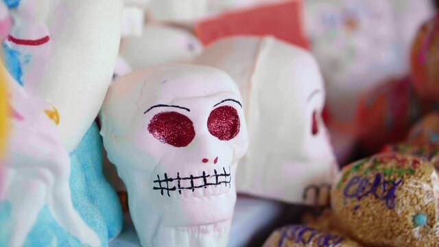 closeup of sugar skulls and amaranth that say "happy" on an altar of the dead during the celebration of the Day of the Dead in Mexico