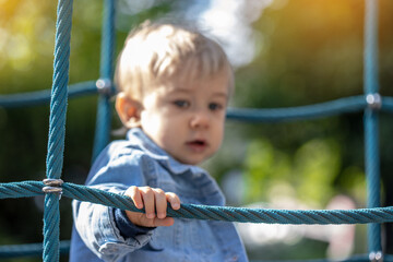 Little blond haired boy playing on the playground