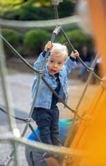 Little blond haired boy playing on the playground