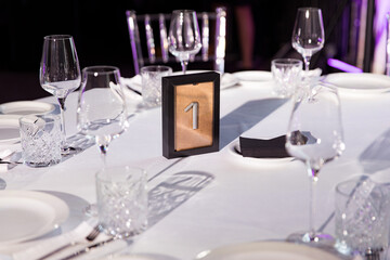 stylish empty glasses and plates at setting at elegant table for wedding reception, catering in restaurant