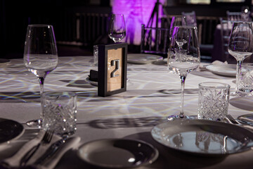 stylish empty glasses and plates at setting at elegant table for wedding reception, catering in restaurant