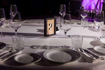 stylish empty glasses and plates at setting at elegant table for wedding reception, catering in restaurant
