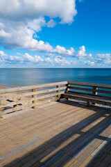 Peaceful seascape over the beach deck with the front water view and dramatic clouds in the vibrant blue sky