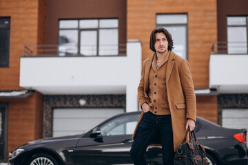 Fototapeta na wymiar Young handsome business man walking out of the house to his car
