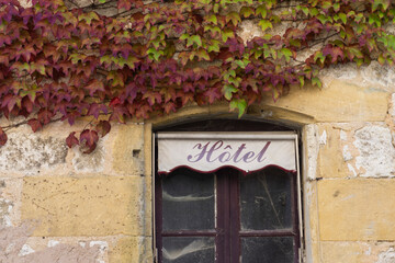 Hotel sign over an abandoned derelict window