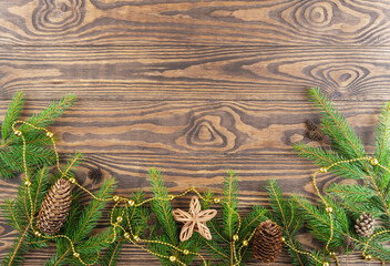 Fir branches with cones and a star on a brown background. Christmas and New Year concept. Horizontal orientation, copy space, top view.