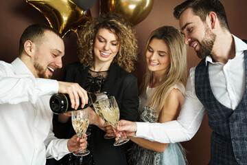 Well dressed party people celebrating  holiday or event and drinking sparkling wine