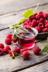 Raspberry alcoholic shots, shot glasses with colored liquor on a wooden  background