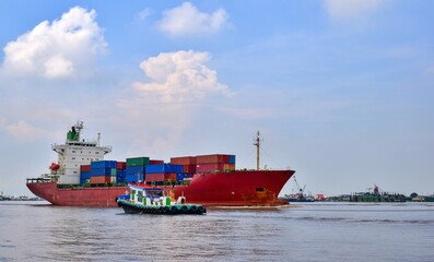 Large cargo ships carrying containers cruising in river canals.