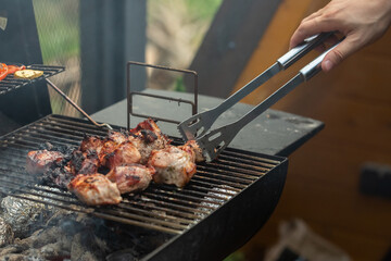 A barbecue grill with tasty juicy steaks are grilled over an open fire.