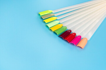 Multiсolor nail tips on a blue background. examples of manicure for nails. Palette with color samples of nail. Copy space