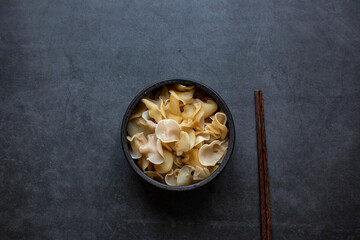 white ear mushroom or white jelly mushroom or white fungus in bowl on dark grey background.