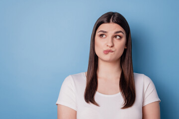 Portrait of pensive thoughtful dreamy lady bite lip look blank empty space on blue background