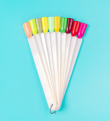 Multiсolor nail tips on a blue background. examples of manicure for nails. Palette with color samples of nail. Copy space