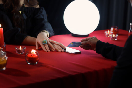 Customer using credit card (mock up) for payment the service form fortune telling, mysterious magnificent fortune teller accepting credit card payments