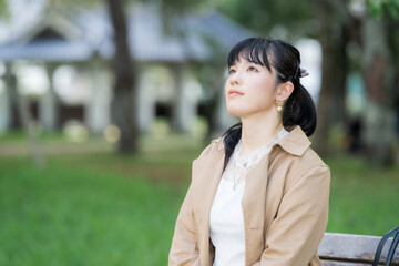 ベンチに座っている女性　見上げる