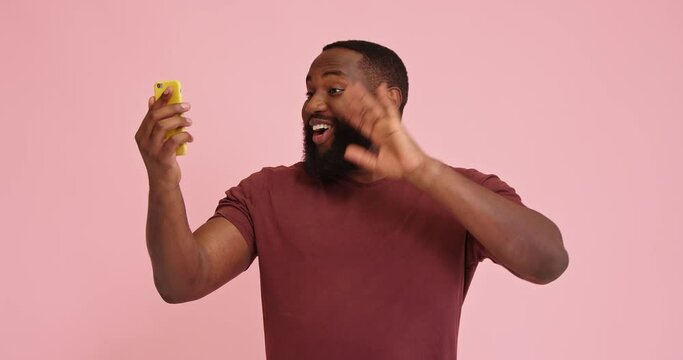 Young African american man make video call isolated on pink background
