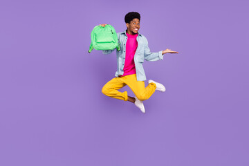 Photo of promoter guy jump hold rucksack hand empty space wear blue shirt isolated violet color background