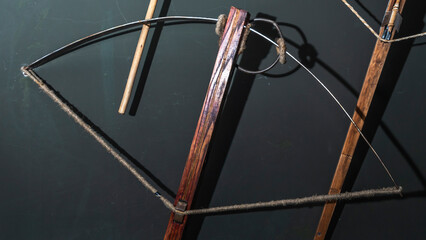 Ancient crossbow handgun on the dark wall background. Old weapon concept.