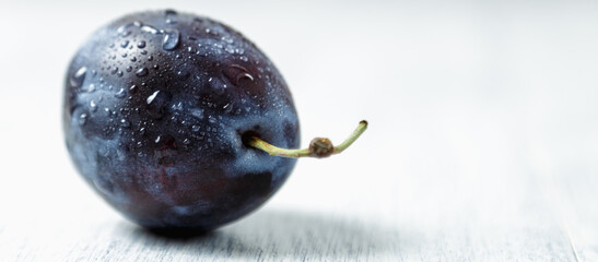 Fresh plums. Fruits. On a white wooden background. Copy space.