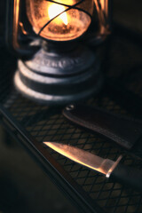 ランタンに照らされるキャンプナイフ