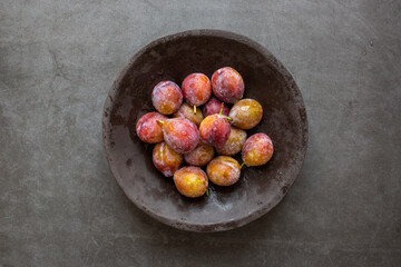 Ripe Plums prunes fruit on dark background.top view