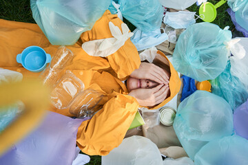 Woman surrounded by piles of rubbish closed her eyes and feeling stressful