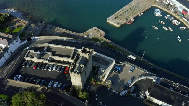 Bullock Castle, Dalkey, Dublin, Ireland, September 2021. Drone gradually orbits from the south while descending pulling across Bullock Harbour with Castle Park School in the background.