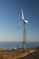 Single wind turbine at sunset. Alternative energy source. Cape Meganom, Crimea.