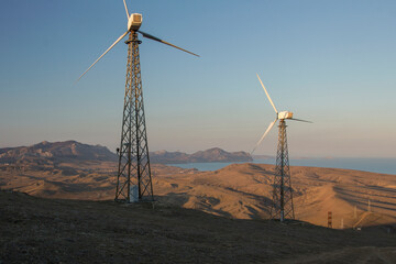 Wind power plant at sunset. Alternative energy sources. Wind turbines farm. Cape Meganom, Crimea.