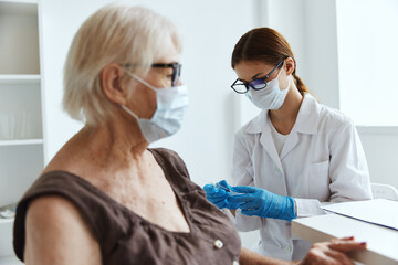 old woman wearing medical mask next to the doctor vaccine passport