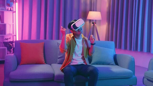 Young Asian Man Wearing Vr Headset And Dacing At Living Room, Cyan And Magenta Colors
