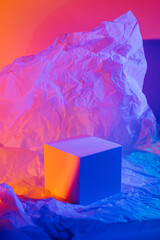 Cube podium with crumpled paper in neon light. Stylish geometric shapes to show  products. Abstract...