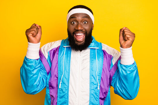 Photo of young black man happy positive smile rejoice victory champion sportsman isolated over yellow color background