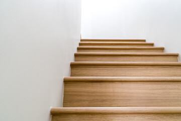 Brown wooden stairs in a modern house from below.