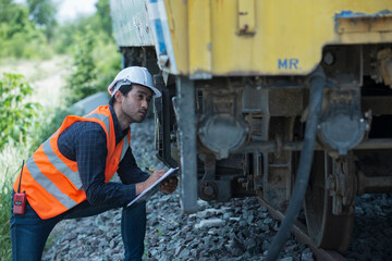worker service and checking  undercarriage of train bogies.