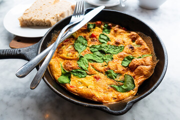 Delicious omelet with fresh lettuce and tomatoes served in a pan for an healthy full breakfast.