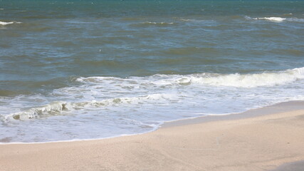 Fototapeta na wymiar Beautiful seascape with beautiful sea waves and sea foam on shore with sea water on beach by sea