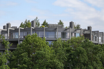 Unique style cube architecture house near riverside with many green trees.