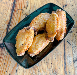 Fried chicken wings on a dark green cup