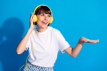 Photo portrait pretty girl smilinglistening music in headphones looking copyspace isolated vibrant...