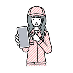 立ってスマートフォンを指差してこちらに向けて見せている作業員の女性