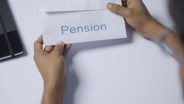 Shoulder shot of man opening received pension money from envelope - concept of retirement pension payments and savings.