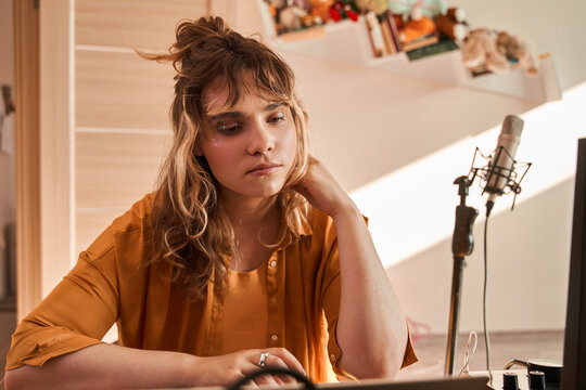 Young Woman Sitting At Her Piano And Thinking What Song Is Play