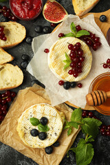 Concept of tasty food with grilled camembert on black smokey background